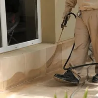 General pest control technician spraying exterior perimeter around a home in Lincoln, NE